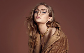 Модель Джиджи Хадид в очках на коричневом фоне