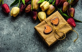 Подарок с букетом тюльпанов на сером столе