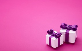 Два подарка с бантами на розовом фоне 