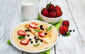 Thin pancakes with blueberries and strawberries for the holiday Maslenitsa 2020
