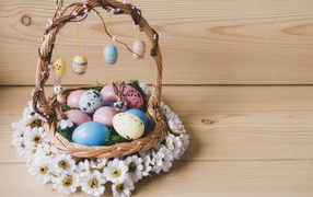 Basket with Easter eggs decorated with flowers.