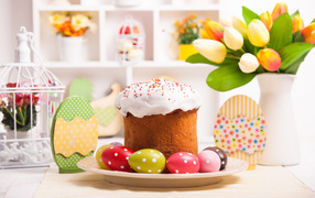 Easter cake with eggs on a table with a bouquet of flowers for the holiday of Easter