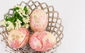Easter eggs in a basket with flowers for Easter