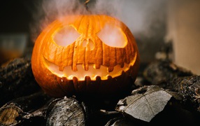Halloween yellow pumpkin with smoke on wood