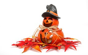 Pumpkin figurine on a white background with leaves for Halloween holiday