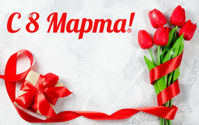 Bouquet of red tulips and a gift with a ribbon for March 8