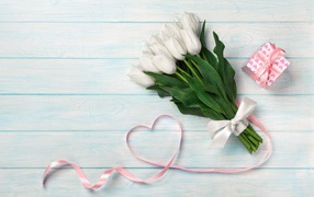 Bouquet of white tulips, pink ribbon and a gift for March 8