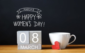 Cup of tea on a table with cubes for International Women's Day March 8