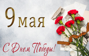 St. George ribbon, a bouquet of red carnations and old photos, a card for Victory Day on May 9