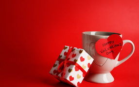 Mug, heart and gift on a red background for Valentines Day
