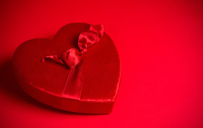 Большое красное сердце с бантом на красном фоне