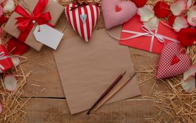 Сердечки из ткани на столе с бумагой и подарками 