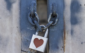 Железный замок с сердцем висит на цепи 