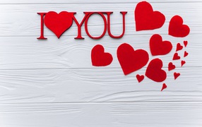 Надпись Я тебя люблю с красными сердечками на столе