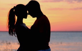 Влюбленная пара на фоне моря в сумерках 