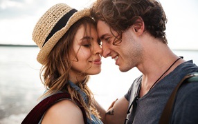 Влюбленная пара стоит на фоне моря 