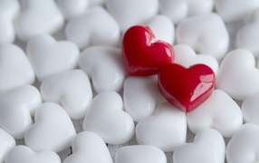Два красных сердца лежат на белых 
