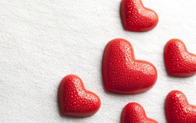 Мокрые красные сердечки на белом фоне