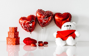 Белый мишка с подарками и шариками у стены