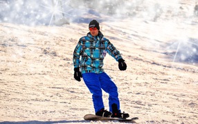 Мужчина сноубордист съезжает с горы 