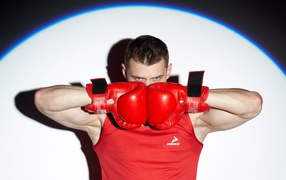 Мужчина боксер с красных перчатках в свете прожектора 