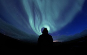 Силуэт мужчины на фоне неба с полярным сиянием