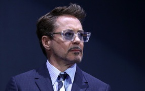 Актер Роберт Дауни-младший в костюме на синем фоне