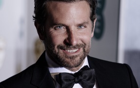 Улыбающийся актер Брэдли Купер в костюме