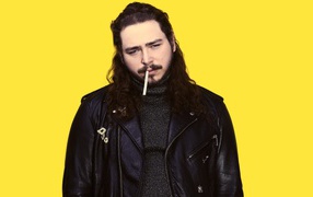 Американский рэпер Post Malone в черной куртке на желтом фоне