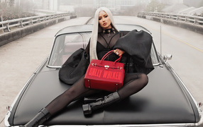 Хип хоп исполнительница Игги Азалия лежит на машине