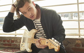 Певец Патрик Дрони с гитарой в руках