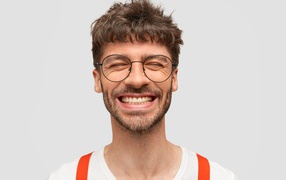 Улыбающийся бородатый мужчина в очках 