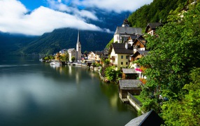 Красивые дома на берегу спокойного озера у подножия гор 