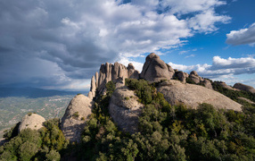 Каменные глыбы под голубым небом с грозовыми облаками 