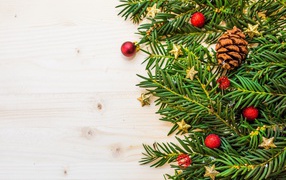 Зеленые ветки ели, шишки и игрушки на белом фоне