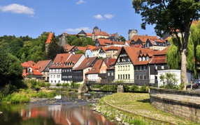 Много домов у пруда на фоне голубого неба