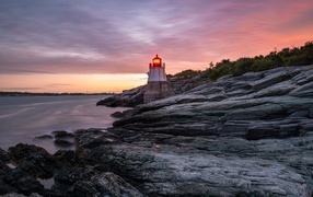 Каменный берег в океане с маяком 