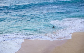 Голубая вода океана на пляже с желтым песком
