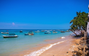 Boats on the shore of a tropical beach on a background of blue sky