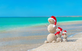 Снеговики из песка на берегу океана 