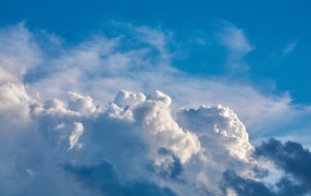 Густые белые облака в голубом небе  в лучах солнца