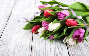 Букет свежих разноцветных тюльпанов на деревянном столе