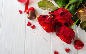 Букет красных роз с конфетами на столе