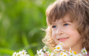 Улыбающаяся девочка с букетом ромашек 