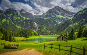 Красивые покрытые зелеными деревьями горы у озера