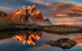 Красивое розовое небо над заснеженными горами у залива 