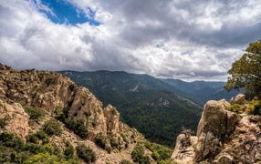 Зеленые вершины гор под белыми облаками 