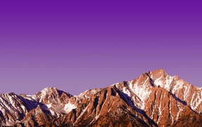 Вершины заснеженных гор на фоне сиреневого заката