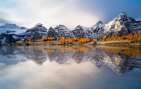 Заснеженные горы отражаются в воде озера 