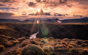 Лучи яркого солнца пробиваются сквозь вершину горы на рассвете 